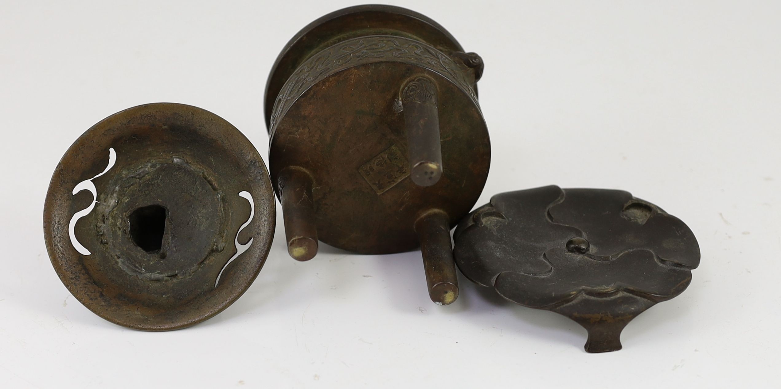 A Chinese bronze tripod censer, ding, Xuande mark, 18th/19th century, with associated cover and stand, 9.5 cm diameter